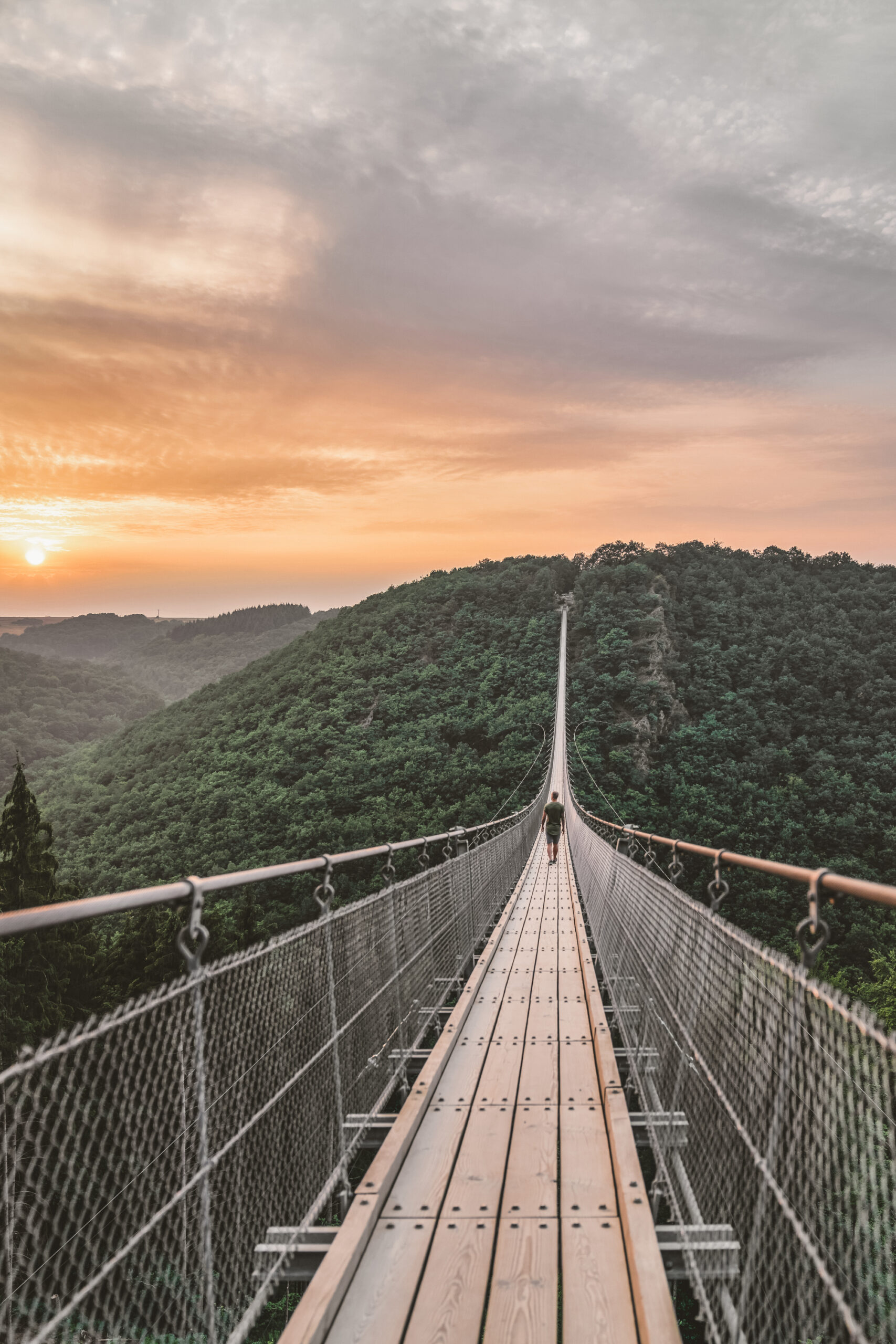 Person Walking Across a Bridge