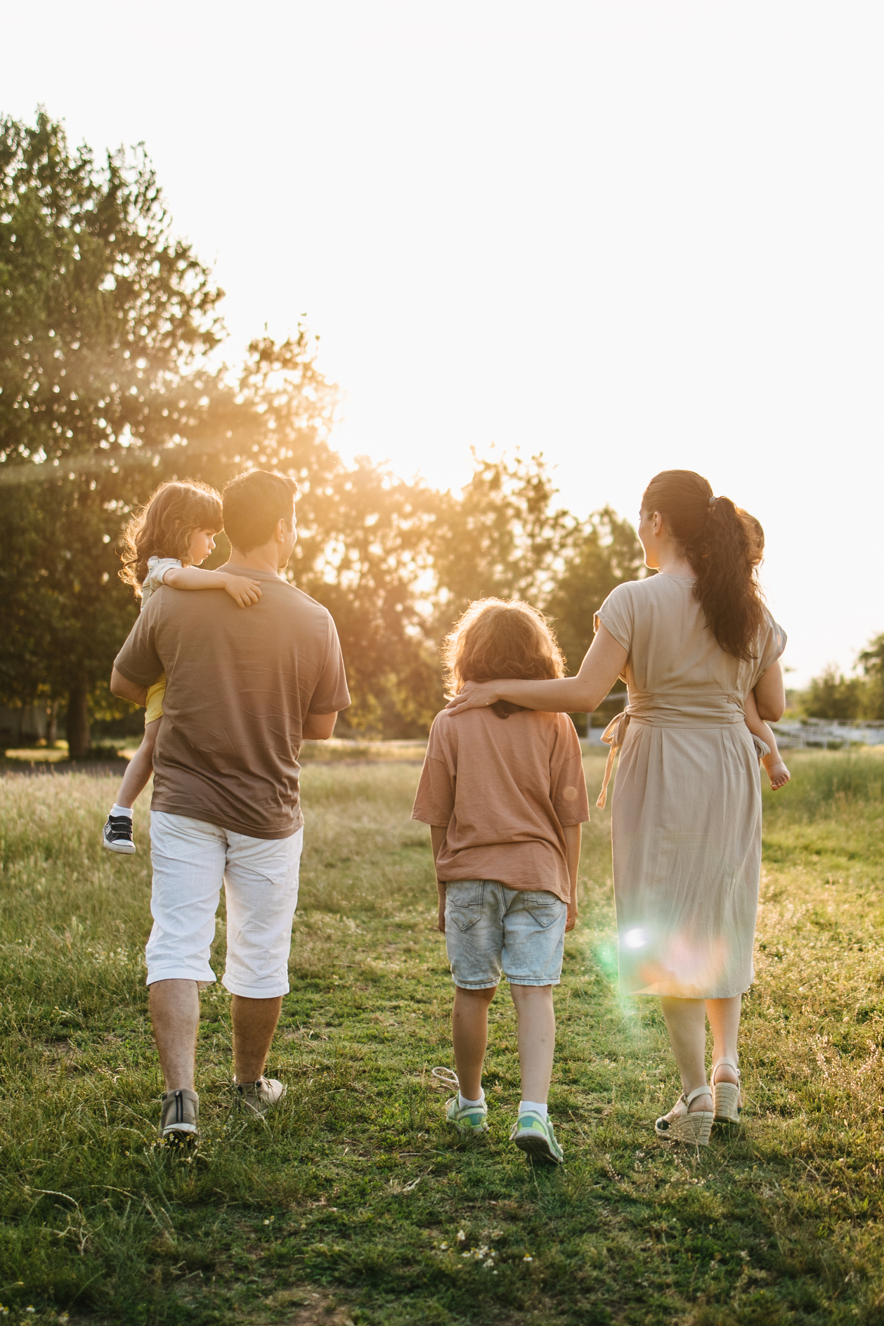 Family Walking Through a Park at Sunset