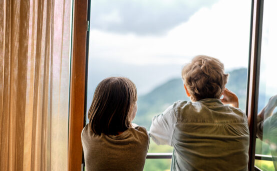 Children Looking Out of a Window Looking at Hillsides