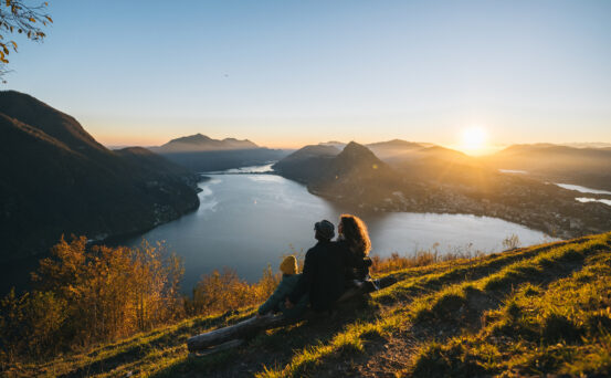 Family Overlooking River and Mountains at Sunset