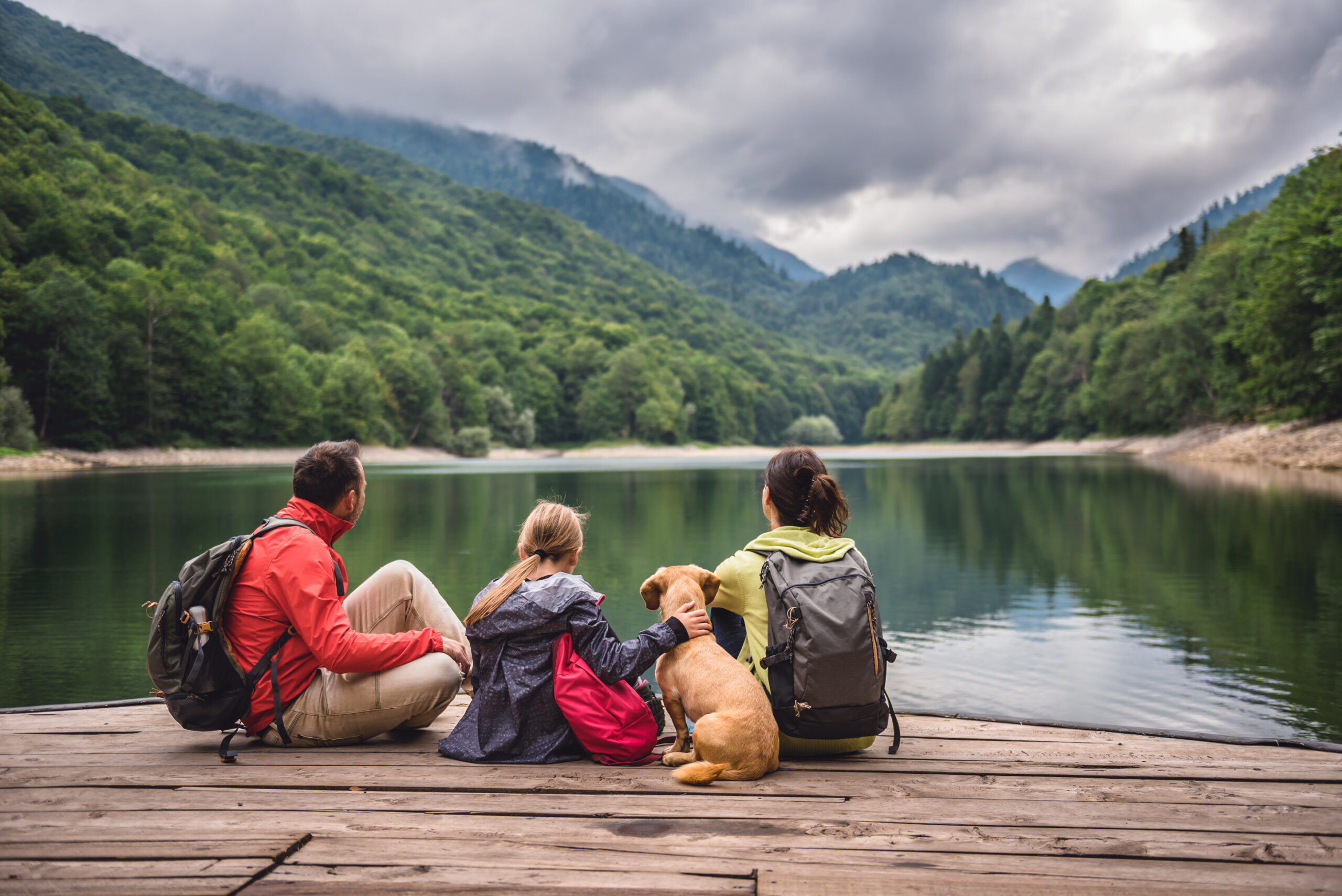 Family Looking at a Lake In Front of Mountains